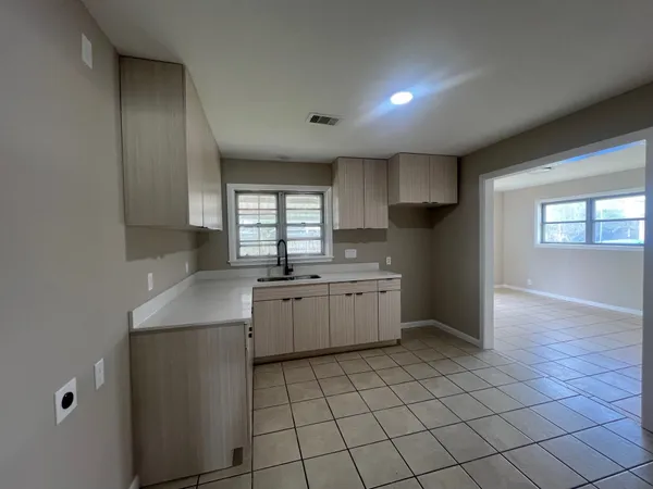 a kitchen with a sink a stove cabinets and utility room