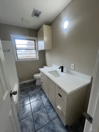 a spacious bathroom with a sink a toilet and a window