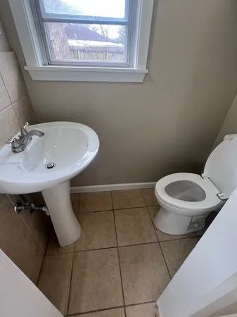 a view of a hallway to a livingroom with wooden floor and staircase