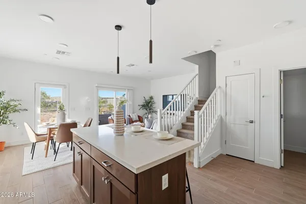a view of kitchen island with stainless steel appliances sink refrigerator dining table and chairs
