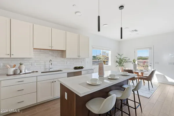 a kitchen with a sink a stove and white cabinets with wooden floor