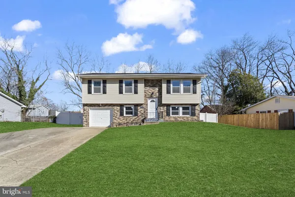 a view of a house with a big yard and large trees
