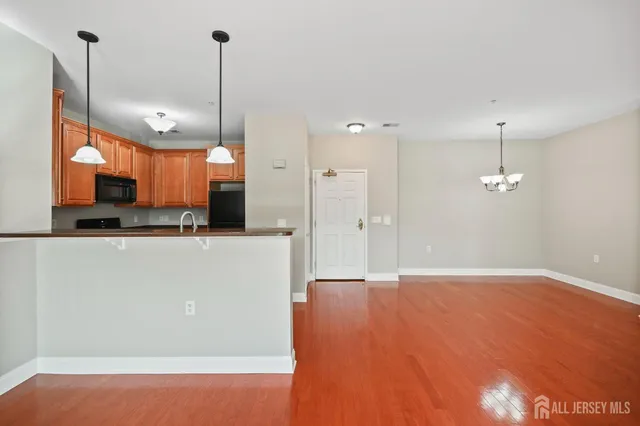 a view of a kitchen with stainless steel appliances granite countertop cabinets and a wooden floor