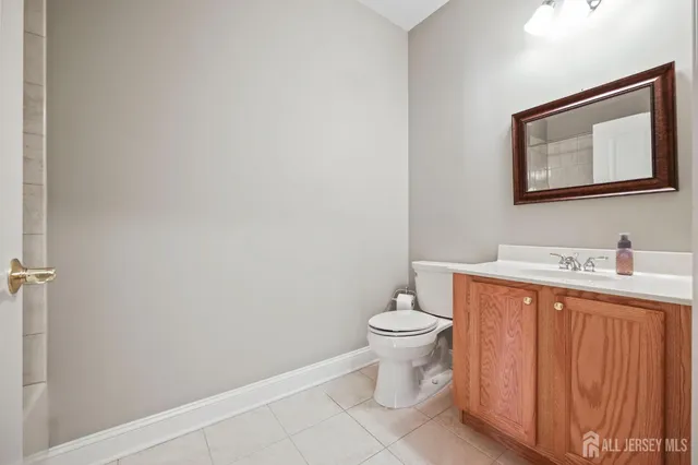 a bathroom with a toilet sink vanity and mirror