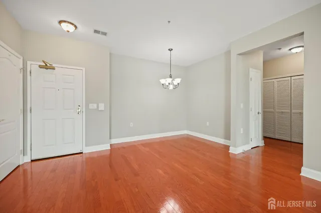 an empty room with wooden floor and mirror