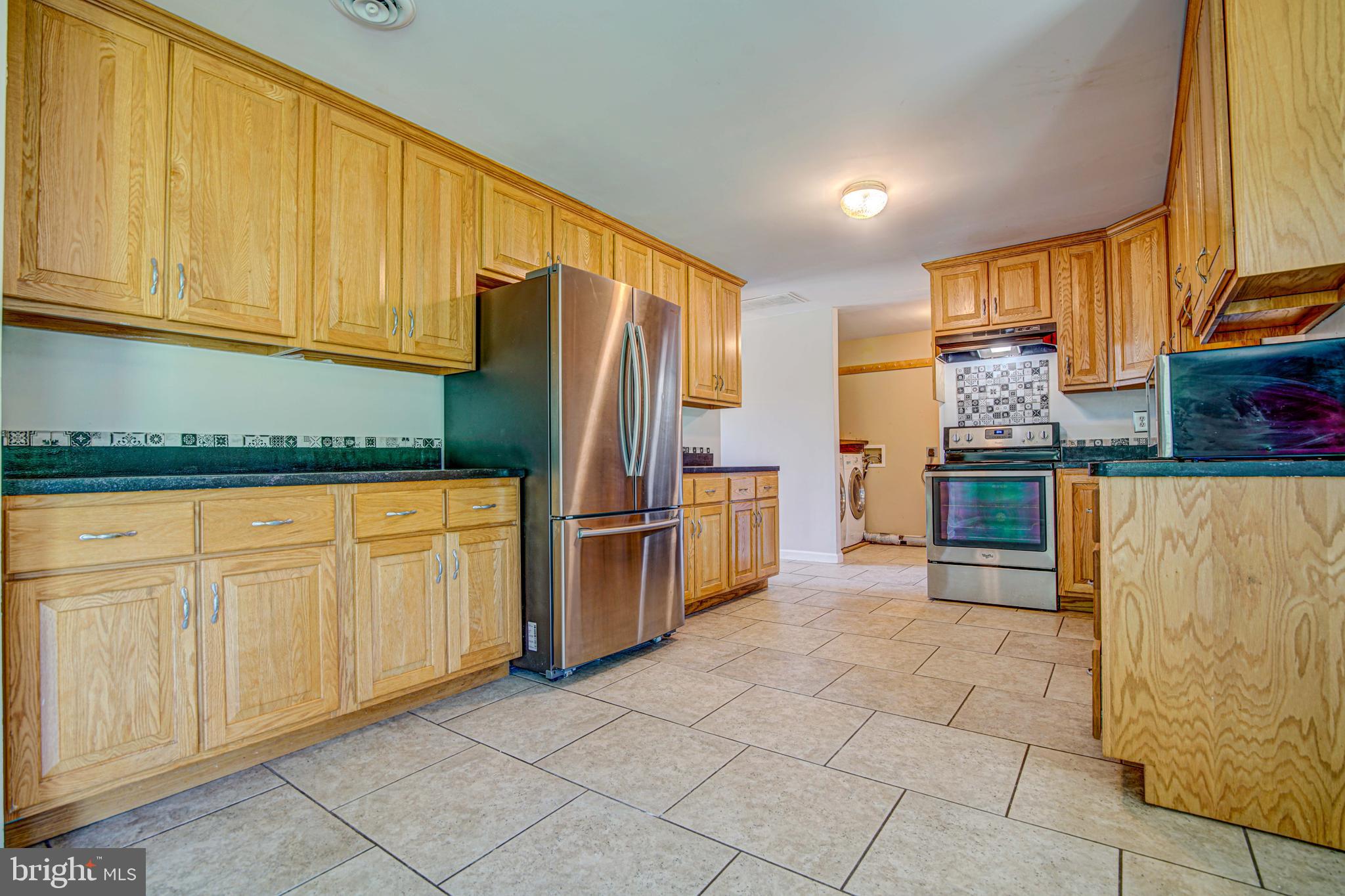1930 Solomons Island Road Huntingtown, MD 20639 - Photo 8 of 21 a kitchen with stainless steel appliances granite countertop a refrigerator and cabinets