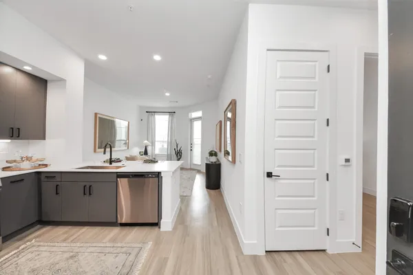 a bedroom with a bed a chandelier and dresser