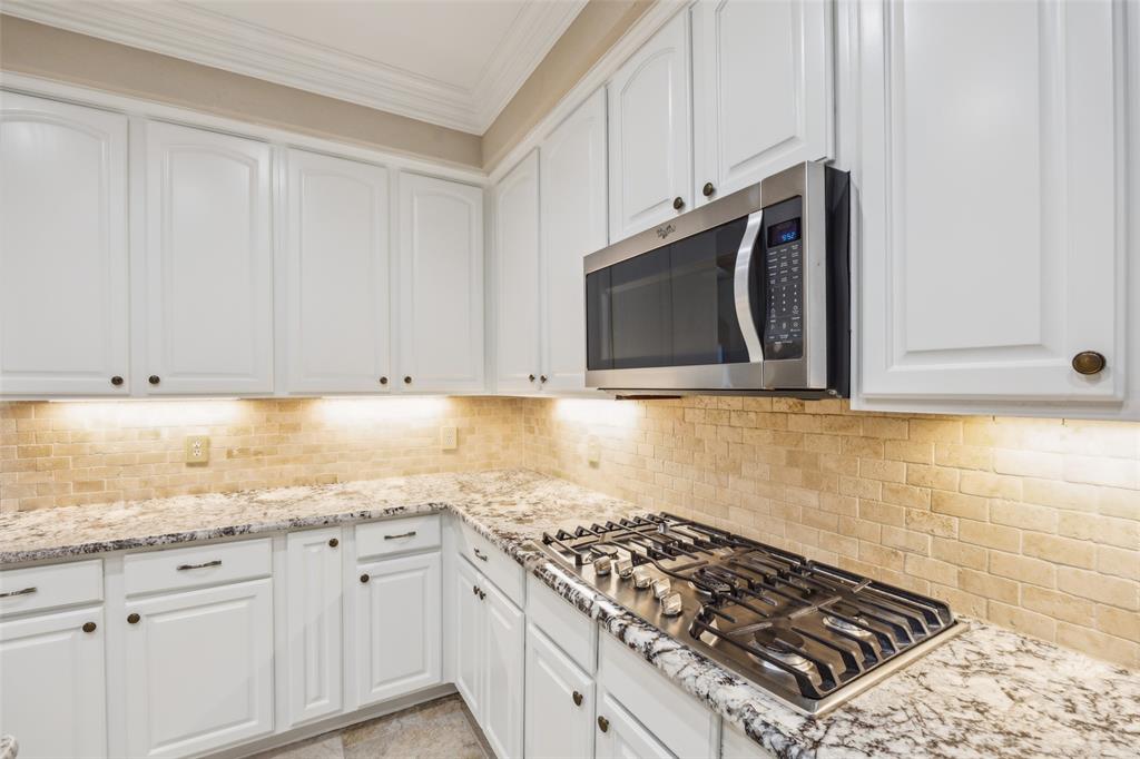 4528 Risinghill Drive Plano, TX 75024 - Photo 14 of 40 a kitchen with granite countertop white cabinets and stainless steel appliances