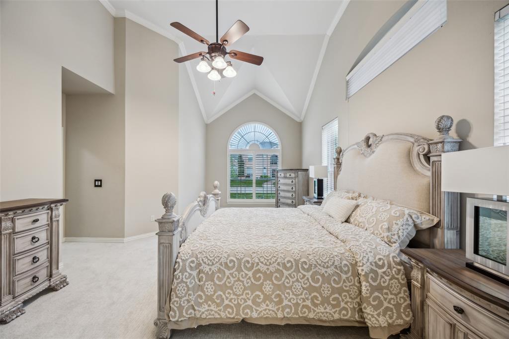 4528 Risinghill Drive Plano, TX 75024 - Photo 20 of 40 a bedroom with a large bed and a chandelier