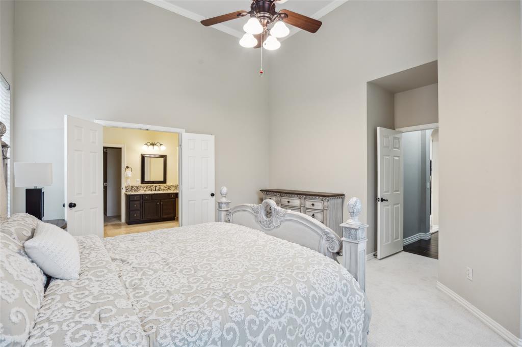 4528 Risinghill Drive Plano, TX 75024 - Photo 21 of 40 a spacious bedroom with a bed and a chandelier