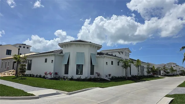 a view of a white house with a yard and table and chairs