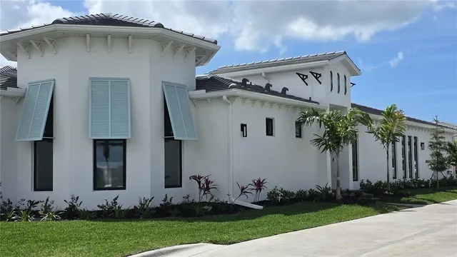 a white house with green field in front of it