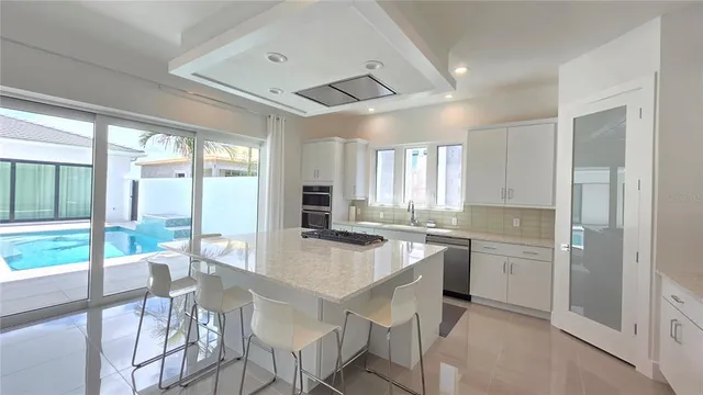 a dining hall with stainless steel appliances granite countertop a stove and a refrigerator