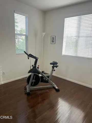 a room with gym equipment and wooden floor