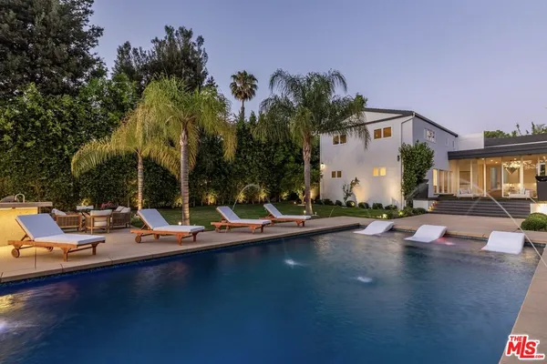 a view of a swimming pool with lounge chairs in patio