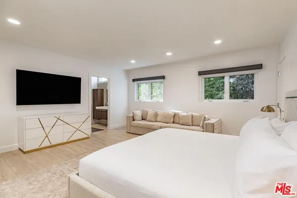 a bedroom with a bed and a flat screen tv