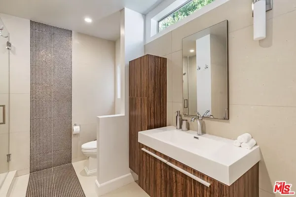 a bathroom with a sink a toilet and a large mirror