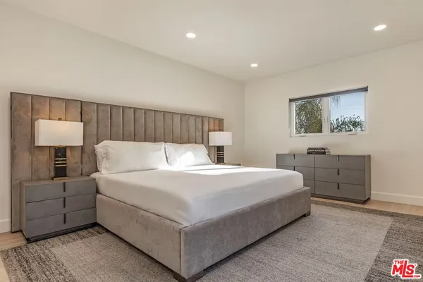 a bedroom with a bed and a night stand
