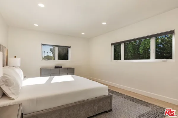 a bedroom with a bed and a large window