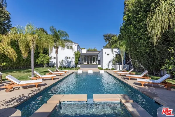 swimming pool view with a seating space and a garden view