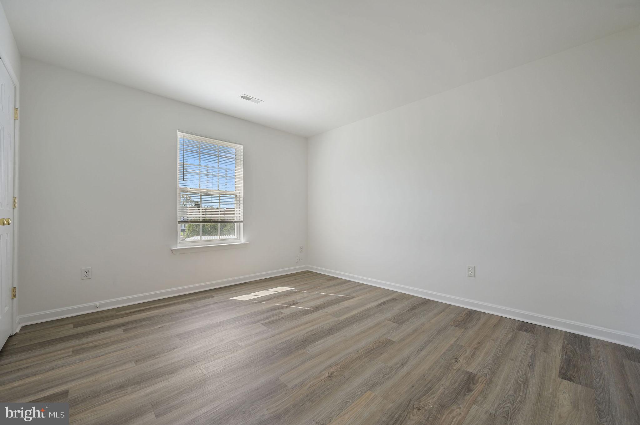 44 Moriarty Street Dover, DE 19901 - Photo 12 of 15 an empty room with wooden floor and windows