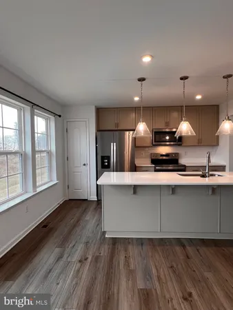 a view of a kitchen with a sink wooden cabinets and a window
