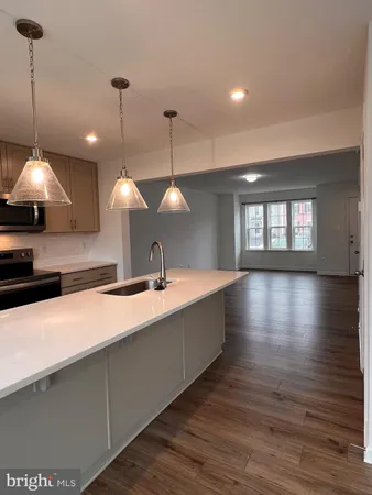 a large kitchen with stainless steel appliances a large island in the center