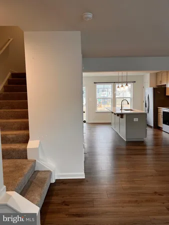 a view of a living room with wooden floor and stairs