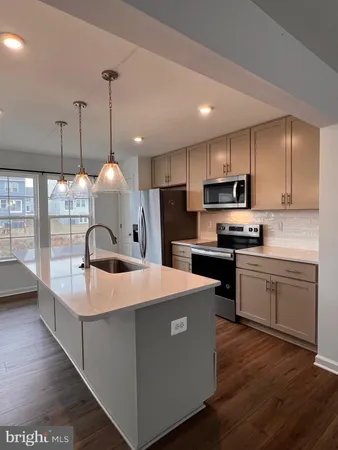 a large kitchen with kitchen island a large island a sink a stove and a center island