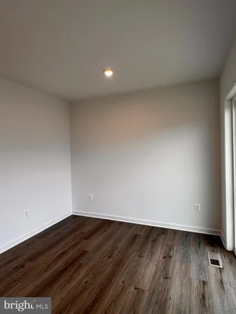 a view of room with wooden floor and white walls