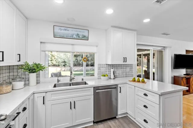 a kitchen with a sink window and cabinets