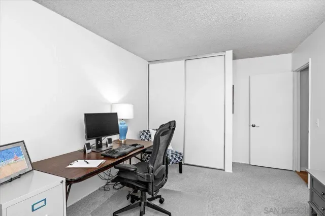 a view of a workspace with furniture and a window