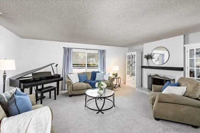 a living room with furniture a fireplace and a window