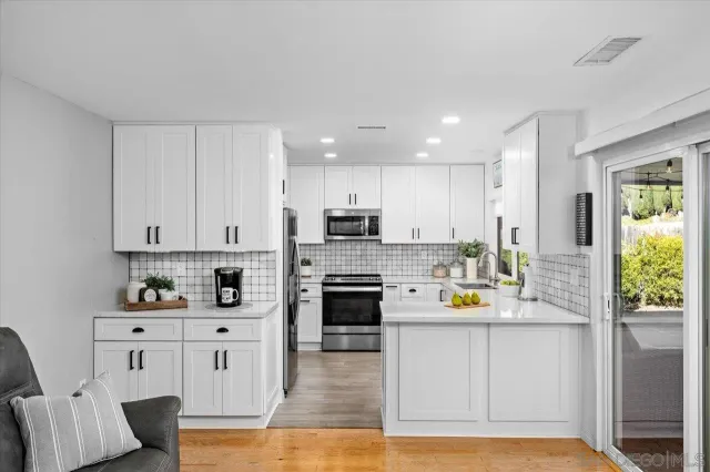 a kitchen with stainless steel appliances granite countertop a refrigerator sink and stove top oven