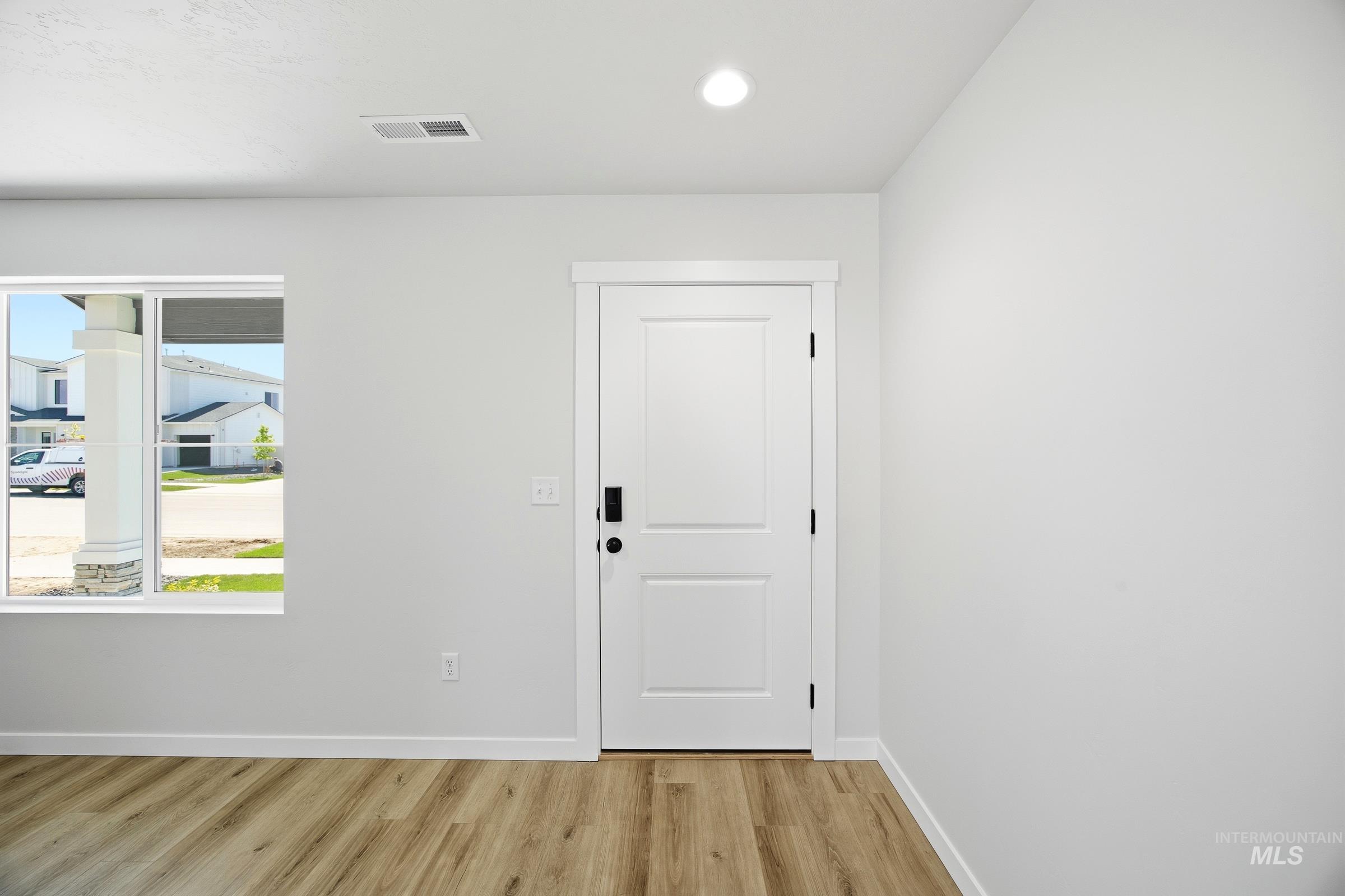 12841 Decatur Street Nampa, ID 83651 - Photo 2 of 30 Entryway featuring a white paneled door, wood-finish flooring, recessed ceiling lighting, a clear window, and white trim