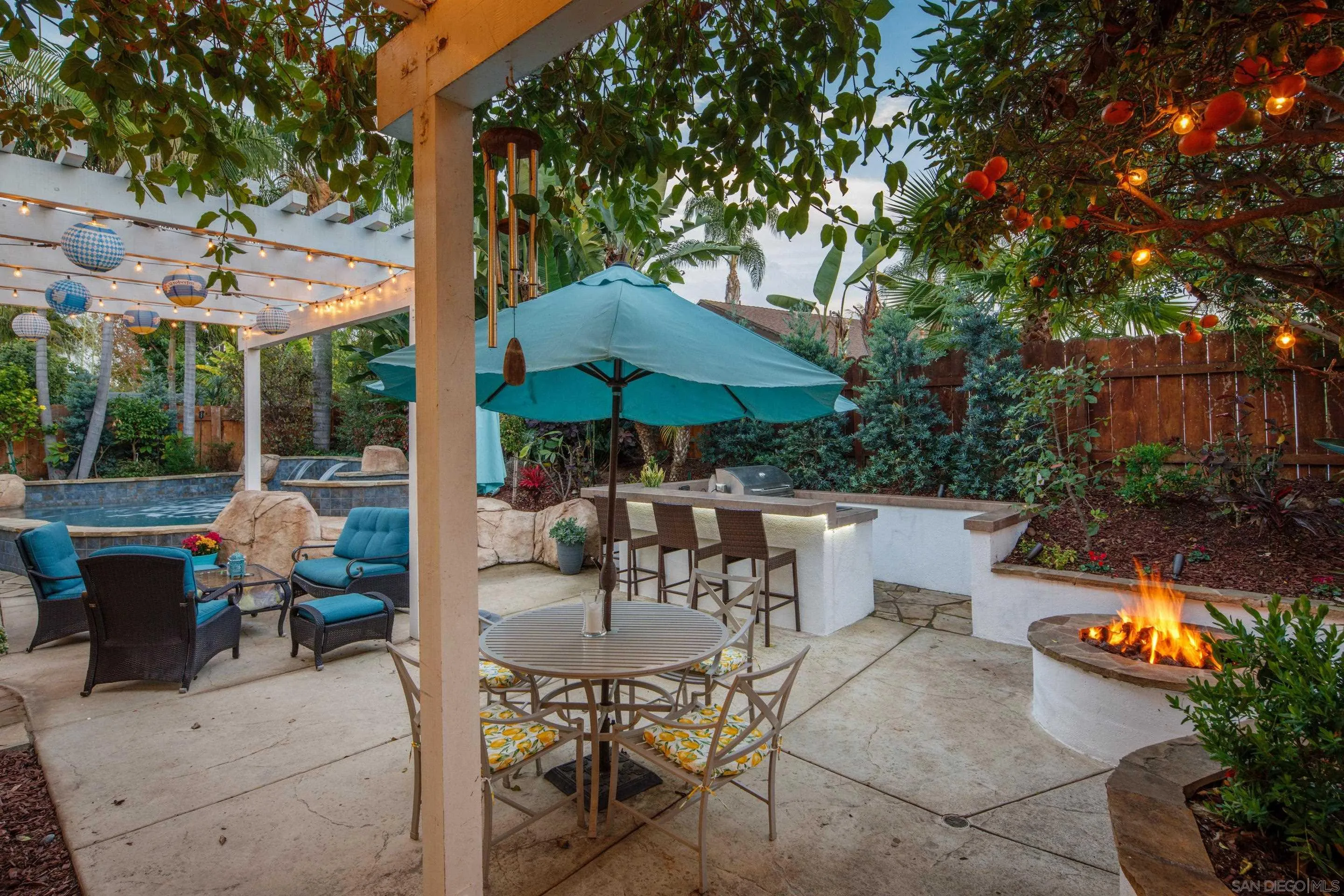 761 Ocean Crest Road Cardiff, CA 92007 - Photo 36 of 37 a view of patio with chairs and table under an umbrella with large trees
