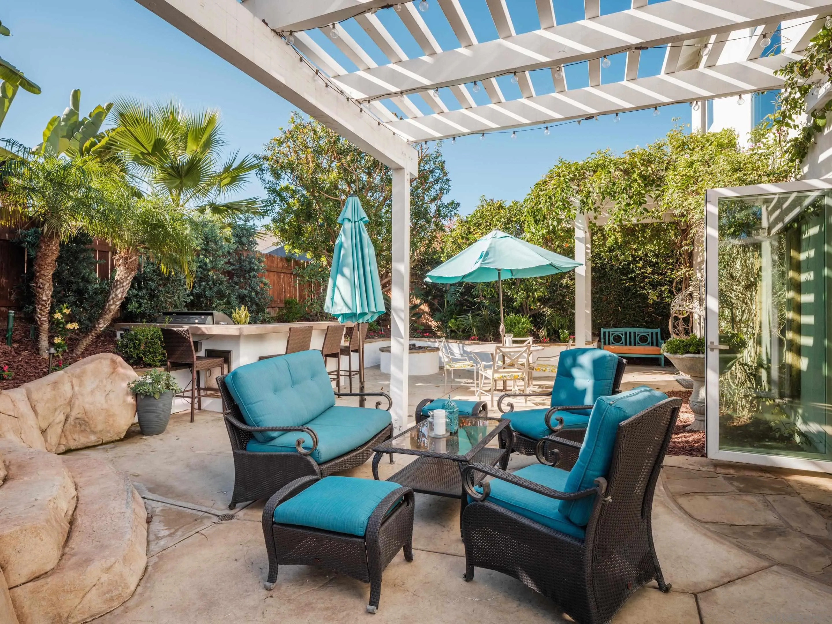 761 Ocean Crest Road Cardiff, CA 92007 - Photo 6 of 37 a view of a patio with couches and table and chairs under an umbrella with a barbeque