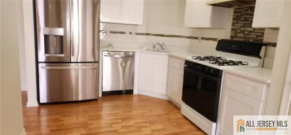 a kitchen with a refrigerator stove and white cabinets