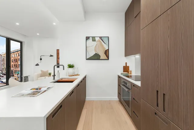 a white kitchen with cabinets and chair
