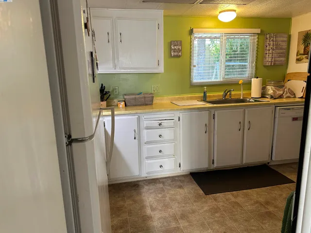 a kitchen with a refrigerator sink and cabinets
