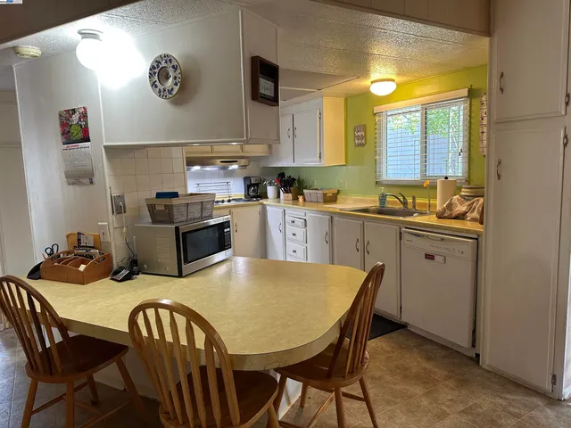 a kitchen with a table chairs sink and cabinets