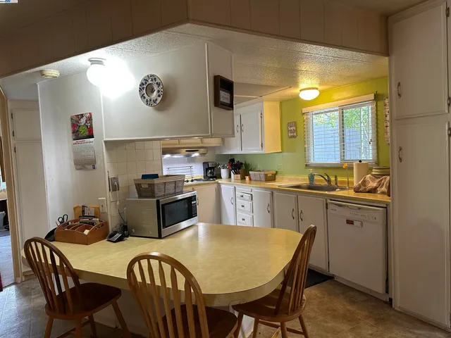 a kitchen with a table chairs and a refrigerator