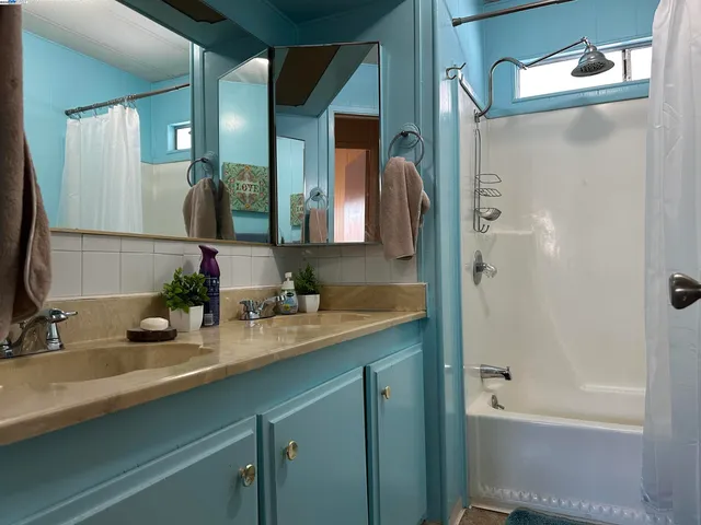 a bathroom with a tub a sink and mirror