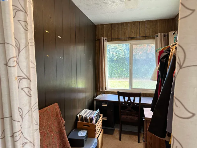 a view of a hallway with furniture and a window