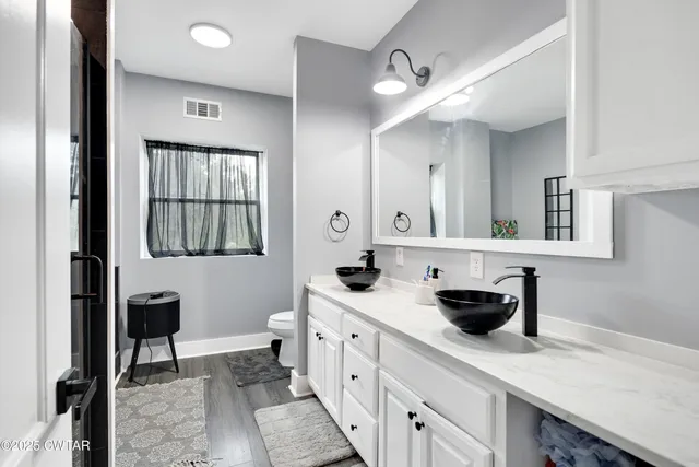 a spacious bathroom with a granite countertop sink and a mirror