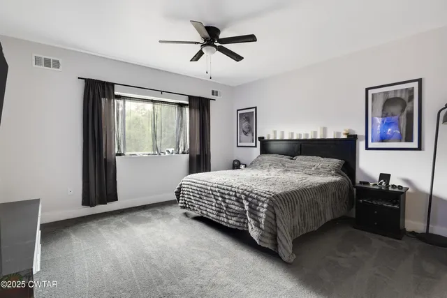 a spacious bedroom with a bed and a window