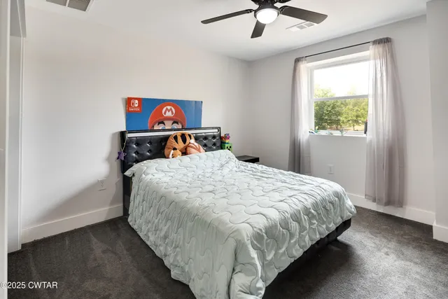 a bed sitting in a bedroom next to a window