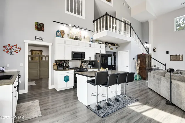 a living room with furniture appliances and kitchen view