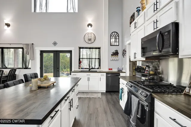 a kitchen with stainless steel appliances a sink a stove and cabinets