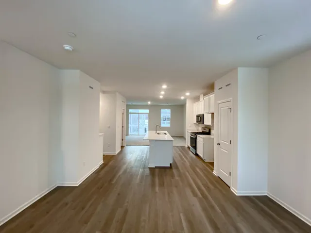 a view of a kitchen with a sink and wooden floor